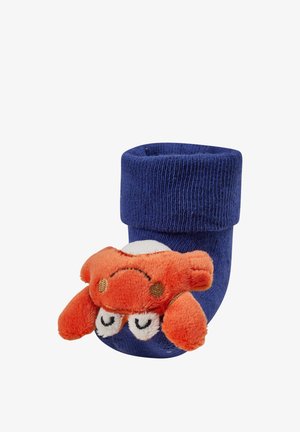 Weicher, blauer Babysocken mit einem plüschigen orangefarbenen Krabbenspielzeug am Knöchel, mit bestickten Augen und einem Lächeln.