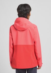 Veste imperméable de couleur corail vif, avec capuche, design bicolore comportant une partie supérieure et inférieure unies, texture lisse et poignets ajustables.