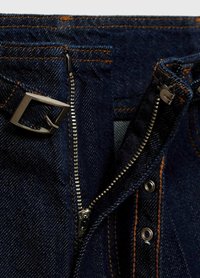 Dark blue denim jeans with contrast orange stitching, featuring a silver zipper and a rectangular metal buckle at the waistband.