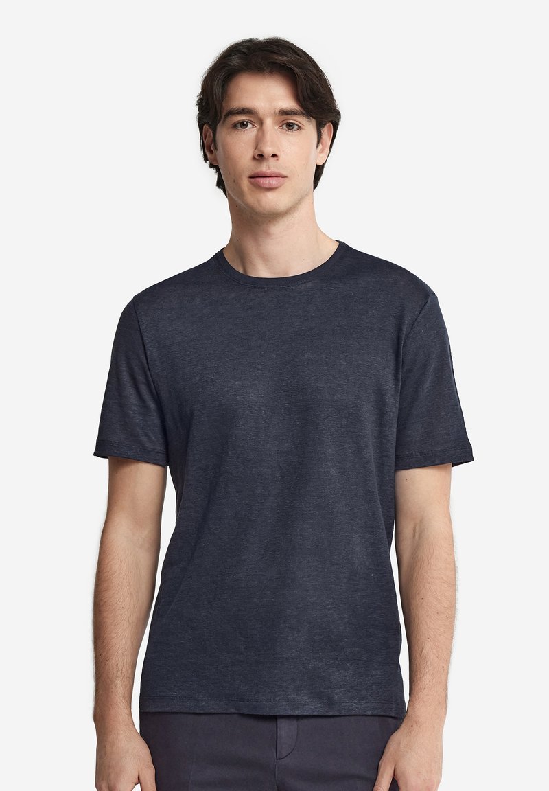 Marinblå kortärmad T-shirt i mjukt tyg med rund halsringning och avslappnad passform. Har minimal textur och inga synliga mönster.