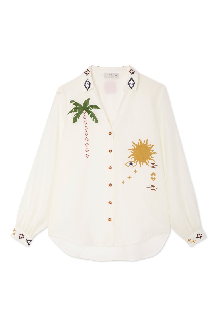 Chemise crème à boutonnage avec motifs de palmiers et de soleil, poignets à motifs noirs et bruns, tissu doux, coupe décontractée et ourlet arrondi.