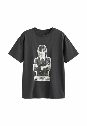 T-shirt noir avec un graphique en noir et blanc représentant une fille aux cheveux tressés, les bras croisés, au-dessus du mot « WEDNESDAY » en texte stylisé.