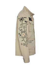 Beige militærjakke med krave, med sorte trykte grafikker, lommer og syningsdetaljer på ærmerne.