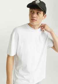 Hvid bomulds t-shirt med en afslappet pasform og korte ærmer. Rundhalssnittet er suppleret af et enkelt design uden synlige mønstre eller prints.