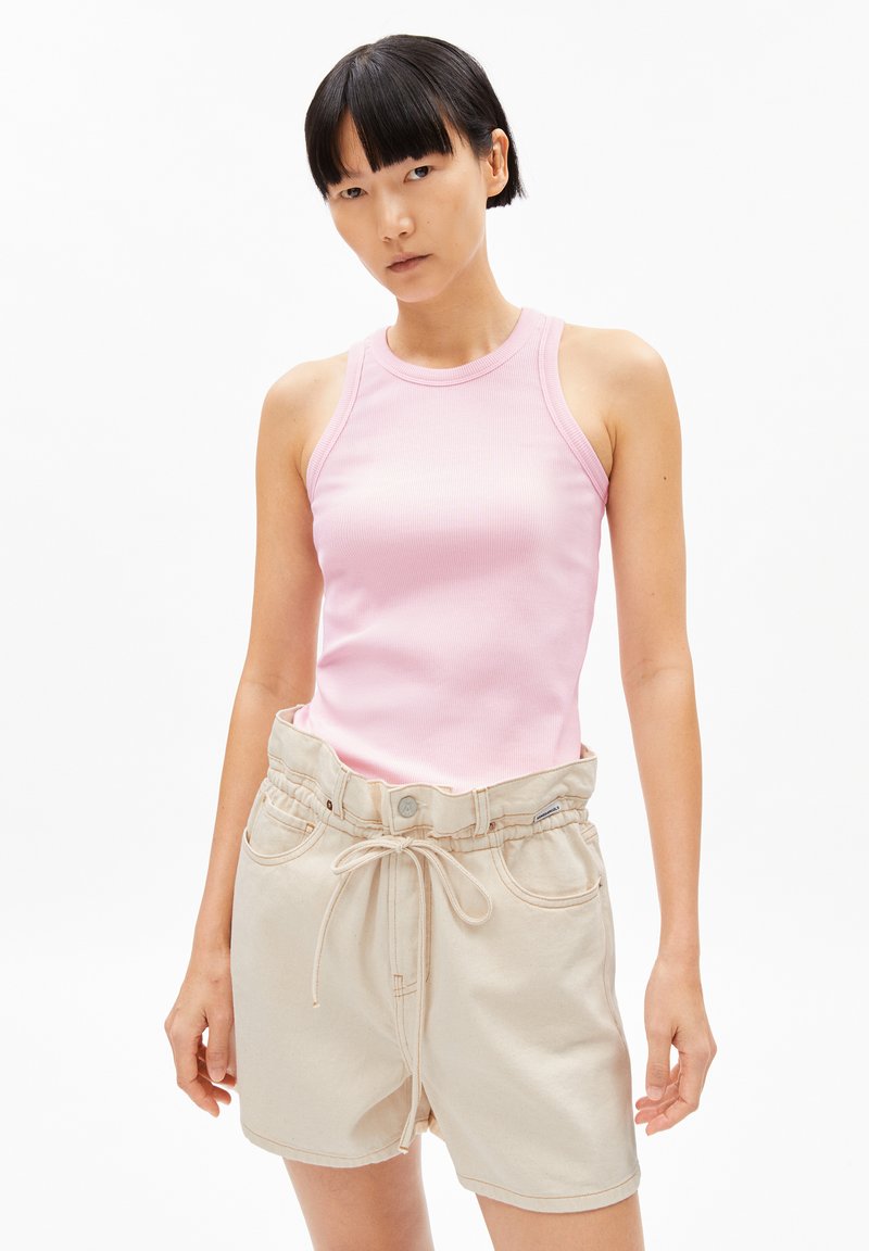 Débardeur en maille rose clair avec un col rond, associé à un short beige à cordon de serrage avec une taille ceinturée et des poches avant.