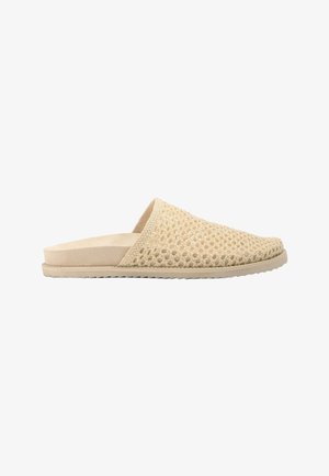 Mule beige à enfiler avec empeigne tissée et semelle plate, offrant un design à tissage ouvert pour la respirabilité et une semelle intérieure rembourrée.