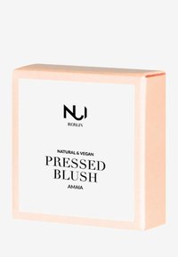Packaging de blush pressé avec une boîte rose clair. L'avant présente une étiquette blanche avec un texte noir : "NUI BERLIN BLUSH PRESSÉ NATUREL & VÉGAN AMAI."