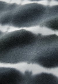 Juoda ir balta medžiaga su banginio raštu, turintį skirtingus tekstūrus; minkšta, nerta medžiaga; sklandus paviršius.