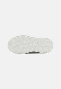 Semelle de sneaker blanche avec un motif texturé. Forme arrondie aux bords lisses, présentant de subtiles lignes de contour pour une meilleure adhérence.