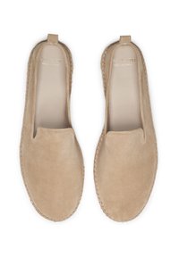 Chaussures slip-on en suède beige avec un bout arrondi, des bords cousus et un intérieur lisse. Pas de quincaillerie ou de motifs visibles. Semelle plate.