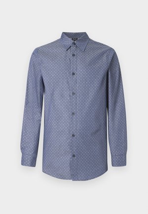 Sinine pikkade varrukatega särgiga, millel on väike valge tähekiri, laia krae ja mustad nööbid ees.