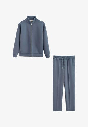 Veste zippée bleu-gris avec col montant et pantalon à cordon élastique assorti à la taille, tous deux en tissu doux.