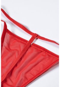 Red mesh bikini top featuring thin straps, a triangular shape, and a central connecting piece. Smooth texture with a subtle sheen.