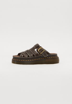 Brun læder sandal med åben tå, tyk sål, gule syninger og justerbar spænde på siden mod en hvid baggrund.