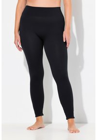 Leggings noires côtelées avec une taille haute, offrant une coupe ajustée sur toute la jambe et une texture lisse et élastique.