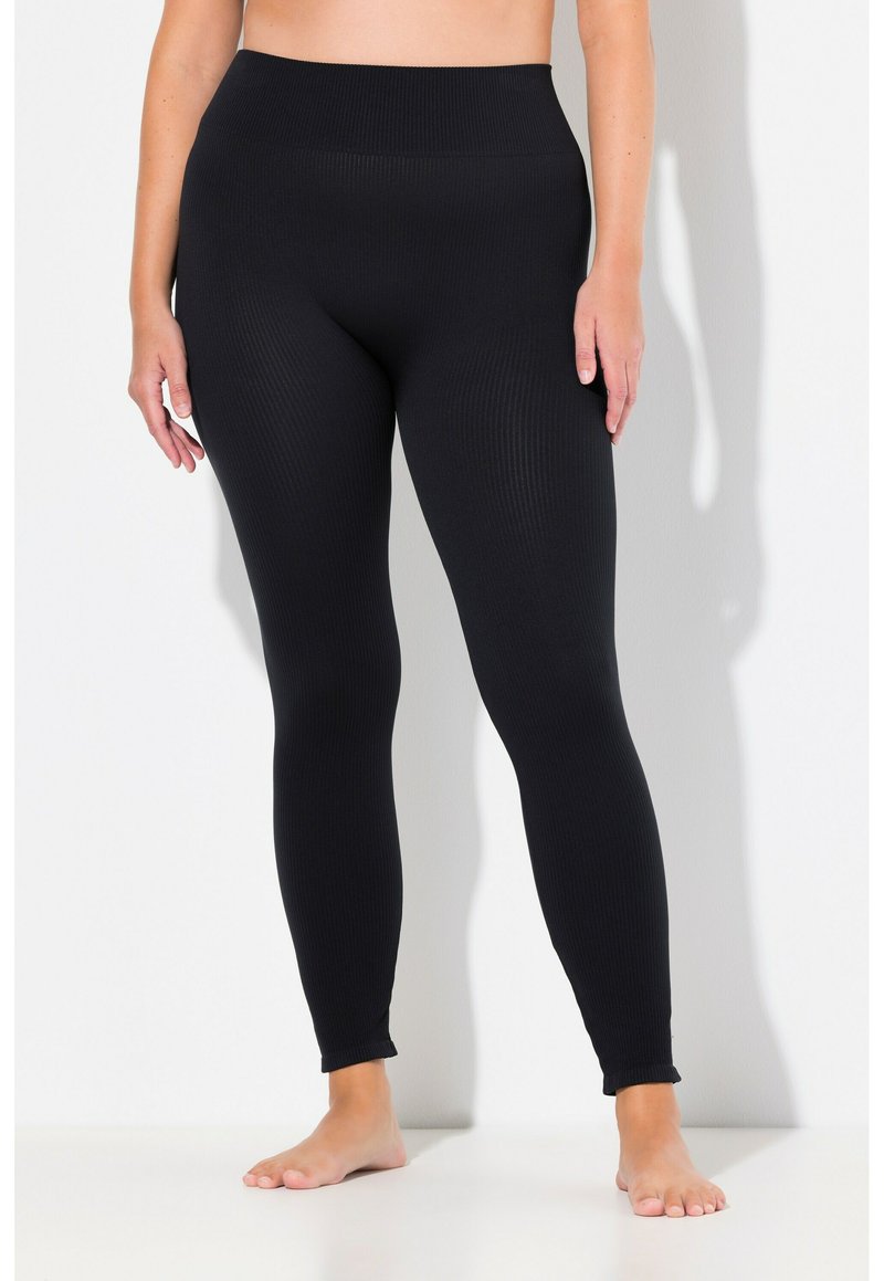 Leggings noires côtelées avec une taille haute, offrant une coupe ajustée sur toute la jambe et une texture lisse et élastique.