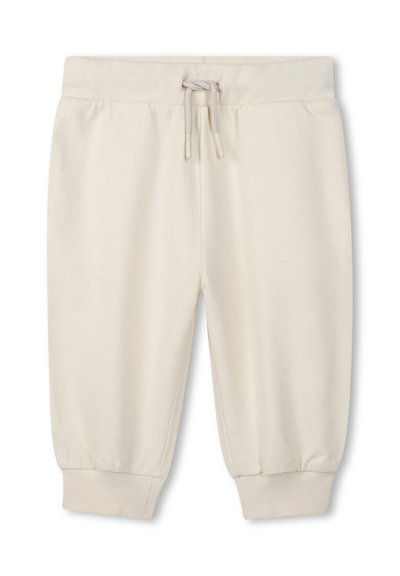 Pantaloni di felpa a coste in tessuto crema, con vita elasticizzata e coulisse, caratterizzati da una texture liscia. Senza ulteriori pattern o dettagli.
