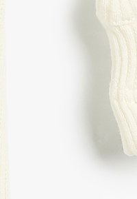 Cremefarbener Strickpullover mit geripptem Muster und runder Ausschnittform. Der Stoff wirkt weich, mit sichtbaren Nähten.