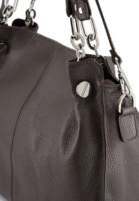 Ciemnobrązowa skórzana torebka o teksturowanej powierzchni, z akcentami srebrnego hardware'u i łańcuszkowymi ramiączkami. Posiada zaokrąglony kształt i metalowe zapięcie na zatrzask.