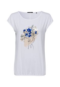 Camiseta blanca de manga corta con un dibujo lineal minimalista de un rostro adornado con flores azules y hojas verdes, sobre un sutil fondo beige.