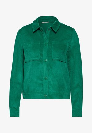 Grønne cordurojakk med krave, frontknapslukning og to brystlommer. Lange ærmer og tekstureret stof.