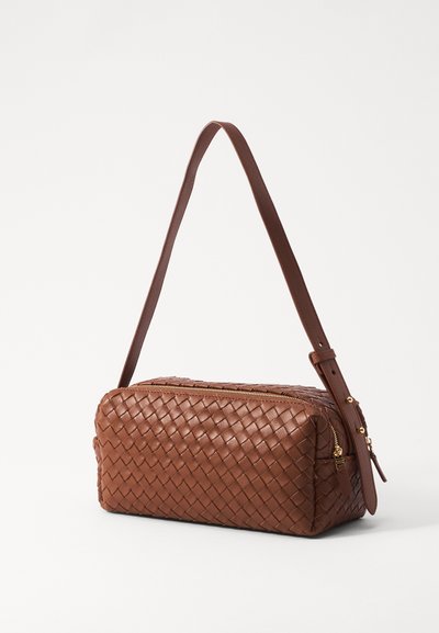 Brown woven leather bag with a rectangular shape, zip closure, and a slender adjustable strap. Features gold-tone hardware accents.