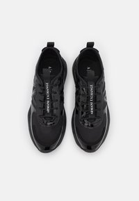 Czarne buty sportowe z siateczkową cholewką i błyszczącymi akcentami. Posiadają logo na języku oraz tonowe sznurówki. Zaokrąglona gumowa podeszwa.