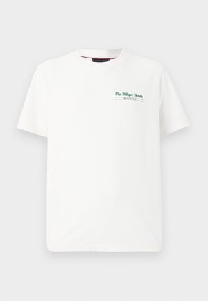 Weißes Baumwoll-T-Shirt mit kurzen Ärmeln, Rundhalsausschnitt, das auf der linken Brust einen grünen Aufdruck mit der Aufschrift "The Milliger Herald" und "MCHLXXXV" zeigt.