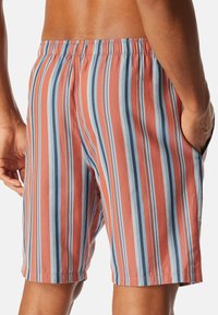 Heren zwembroek met verticale strepen in tinten van koraal, blauw en lichtblauw. Elastische tailleband en zijzakken. Zachte stoftextuur.