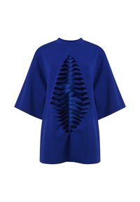Camiseta azul de manga corta y corte holgado, con un frente texturizado que presenta detalles en capas con volantes, creando un contraste de diseño llamativo.