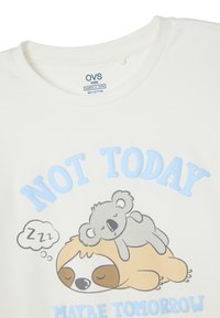 Camiseta blanca de algodón con un gráfico azul que presenta el texto "NO HOY" sobre una ilustración de un perezoso y un koala durmiendo.