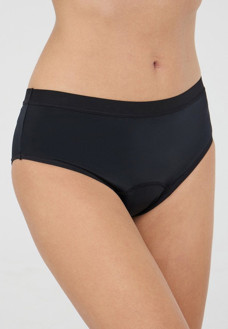 Culotte nere a vita alta con una texture liscia e lucida e una ampia fascia elastica in vita. Progettate per comfort e una vestibilità senza cuciture.