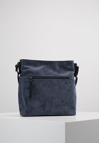 Navyblauwe synthetische handtas met een slouchy ontwerp, verstelbare schouderband, voorvak met rits en een gladde, textuurafwerking.