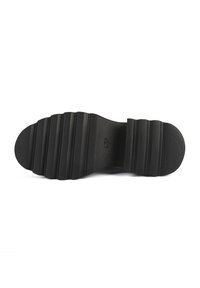 Semelle de chaussure en caoutchouc noir avec de profondes rainures horizontales, surface texturée, et une marque de taille visible "L37" au centre.