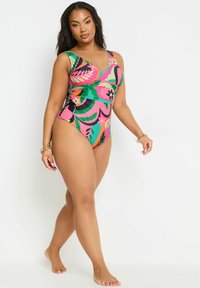 Maillot de bain une pièce multicolore avec un décolleté en V, des motifs floraux en rose, vert et orange, et un design froncé sur le côté.