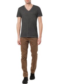 Tmavě šedé tričko s v-výstřihem a krátkými rukávy, ve spojení s hnědými chinos kalhotami a černými kotníkovými botami, umístěné na neutrálním pozadí.