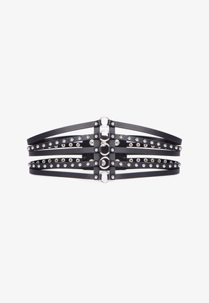 Zwarte leren korsetriem met meerdere horizontale banden, zilveren studs en ronde zilveren bevestigingshardware in het midden.