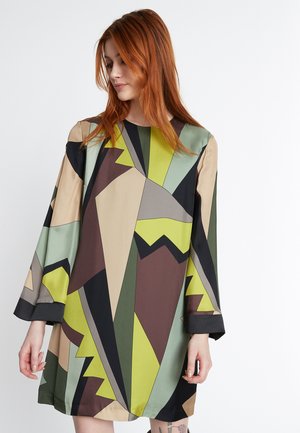Geometrisch patroon jurk met een mix van groen, bruin en beige. Het ontwerp bevat hoekige vormen en lange mouwen met een zwarte zoom.