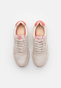 Sneakers beige realizzati con materiali in rete e scamosciato, con accenti rosa chiaro sul tallone e sulla linguetta. Inclusi lacci e un'etichetta con il logo.