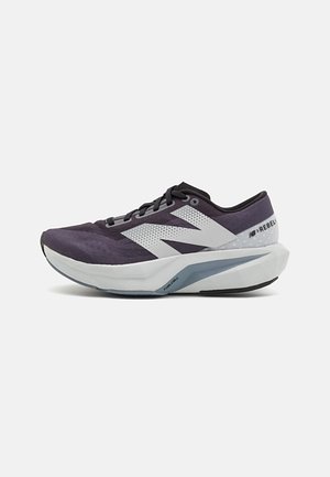 Zapatilla deportiva morada con parte superior de malla, acentos blancos y una suela gris gruesa y acolchada con un diseño texturizado.
