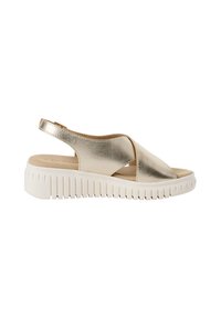 Sandale slingback métallique dorée avec des brides croisées, semelle intérieure crème et semelle en caoutchouc blanche dotée d'une texture striée pour une bonne adhérence et stabilité.