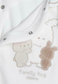 Weißer Baby-Overall mit Druckknopfverschluss, der auf der Vorderseite beigen gestickte Tiere und den Text "Familienumarmung" in hellem Stich aufweist.