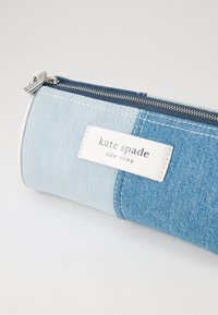 Denim pencil case in light and dark blue shades, featuring a silver zipper and a white label with "kate spade NEW YORK" embossed.