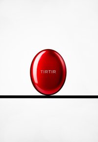 Red oval compact with a glossy finish, featuring silver "TIRTIR" branding. Positioned on a thin black line against a white background.