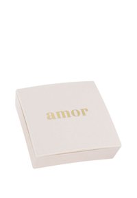 Scatola quadrata di un rosa chiaro con bordi arrotondati e la scritta "amor" in oro sul fronte. Texture liscia, design minimalista, coperchio chiuso.