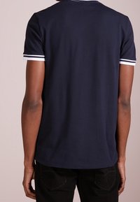 Námořnická modrá polo košile s krátkým rukávem a bílým pruhovaným límcem a lemy rukávů, vyrobená z hladké tkaniny, slim fit střih s rovním lemem.