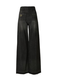 Fekete, széles szárú farmer, lyuggatott textúrával, rojtos szegéllyel és két hátsó zsebbel. Márkajelzés látható a derékpánton.