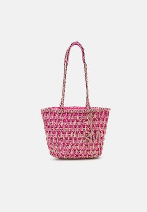 Sac cabas tissé rose avec anses en chaîne et un petit pendentif en chaîne suspendu sur le côté, sur un fond uni.