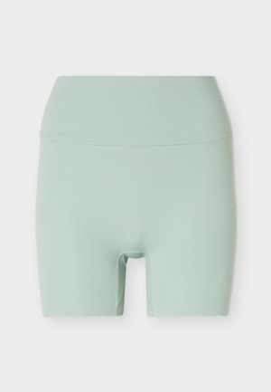 Shorts de cycliste sans couture, taille haute, vert pastel, longueur jusqu'à mi-cuisse avec une texture de tissu lisse.