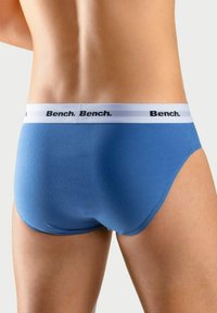 Blauwe katoenen slips met een witte tailleband waarop het zwarte "Bench." logo staat. Gladde textuur en strakke pasvorm, met een minimalistisch ontwerp.